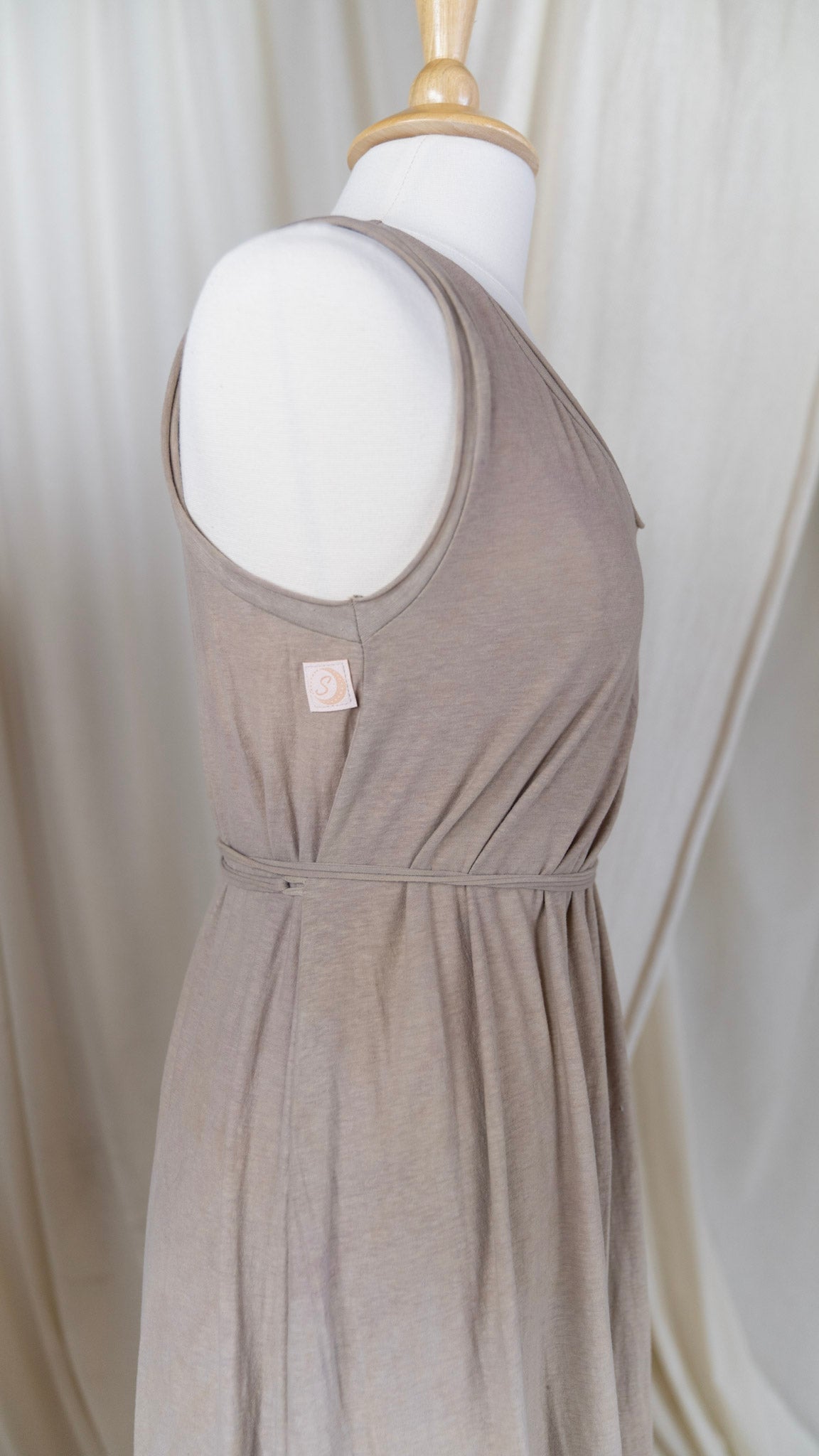 close up of tan dress with belted waist and visible tag