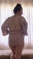 backside of woman's body with robe pulled up above waist showing her wearing nude period underwear