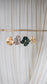 Several oversized scrunchies in various hues and fabrics hanging from a piece of driftwood